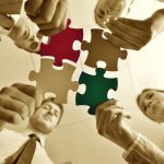 Group of business people assembling jigsaw puzzle and represent team support and help concept