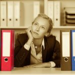 Bored Young Businesswoman With Binders