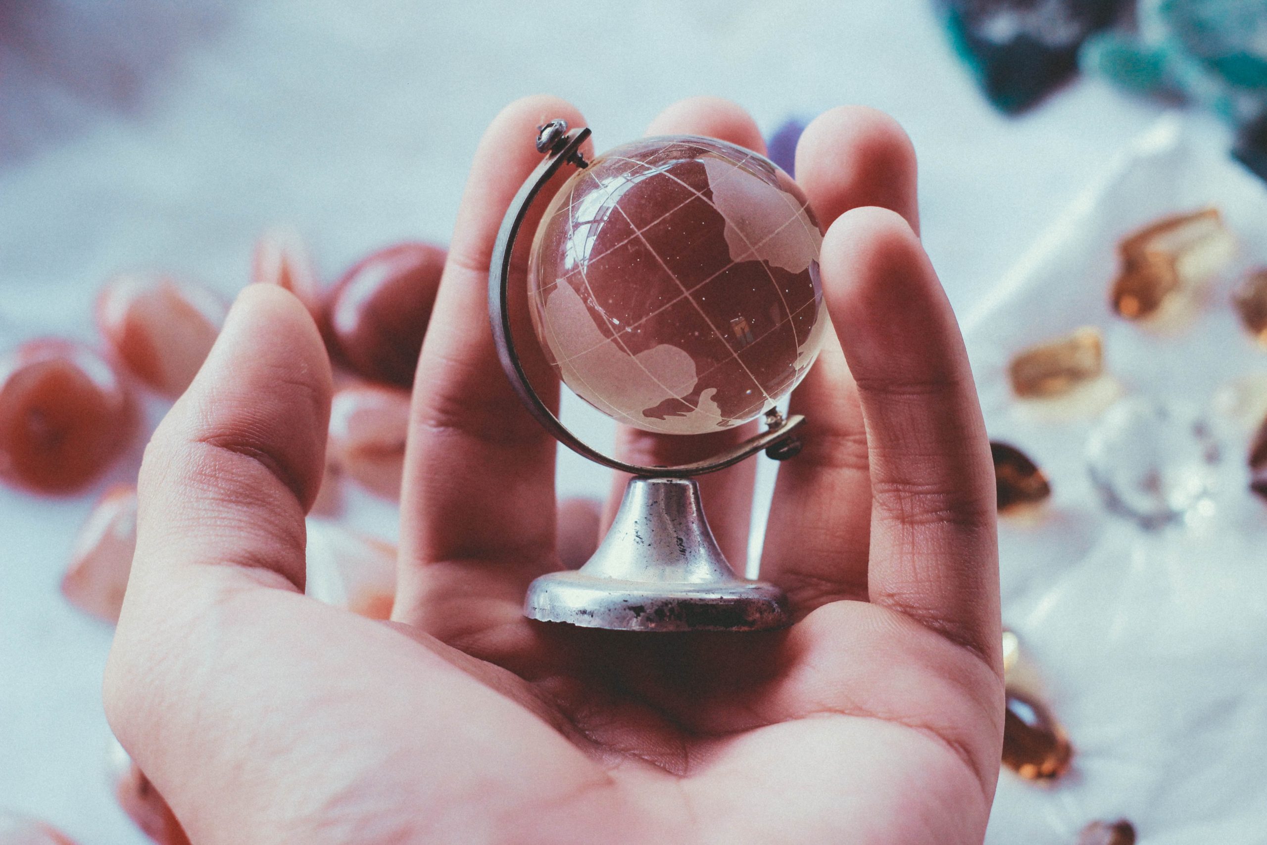 a hand holding a small globe to represent relocating in big 4 accounting firms
