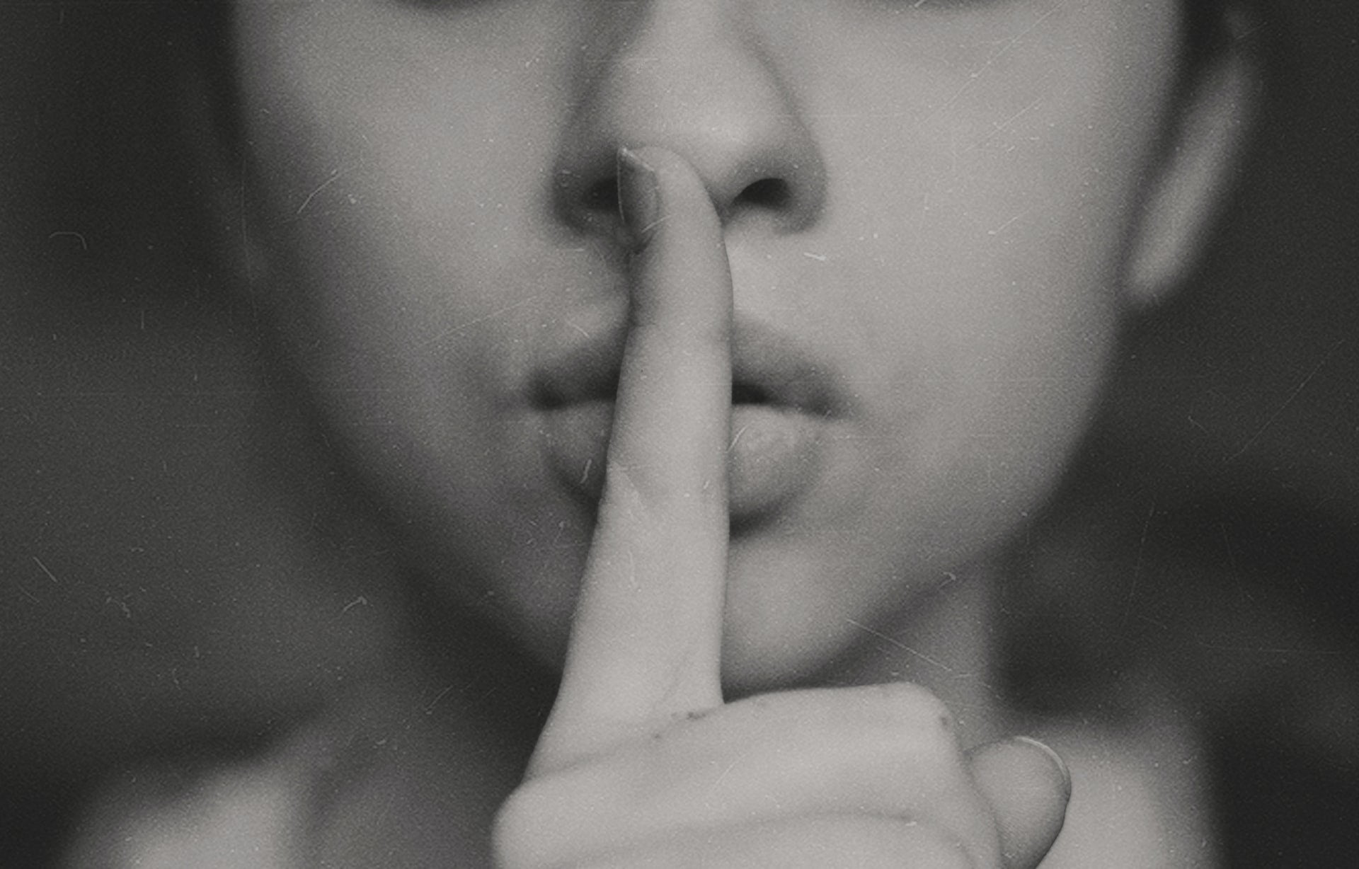 a woman with her finger on her lips to symbolise secret job searching tips